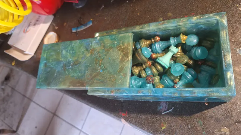 An epoxy resin box for chess pieces, in green and azure