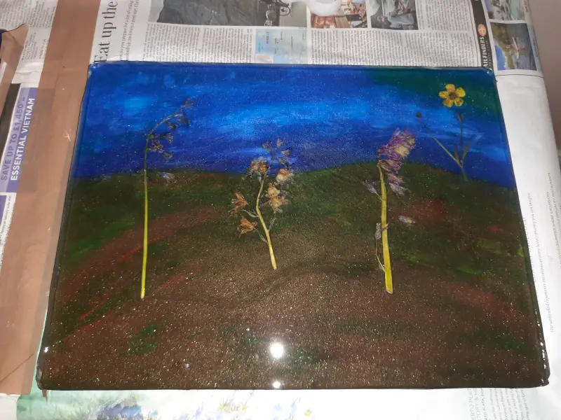 A decorative flower press with dried flowers, completed with cured epoxy resin