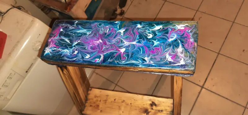 A wintry epoxy resin pattern, in blue white and mauze, from a long term project to convert an old wooden stepladder into a planter