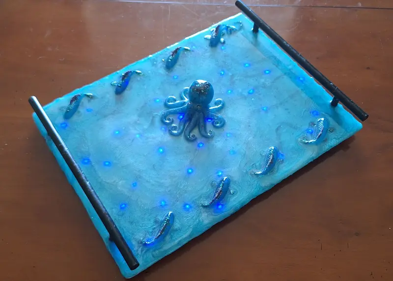 An epoxy resin tray, in ocean blue, with decorative octopus and fish